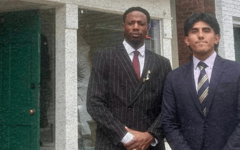 JoeyBadda$$ and Gerald wearing tailored suits outside a shop, representing men’s clothing alterations in Jersey City.